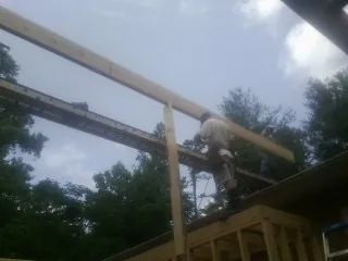 Carpenter setting a ridge beam over a new addition frame — Ice Dam Removal by Roofing Brothers in Kyburz