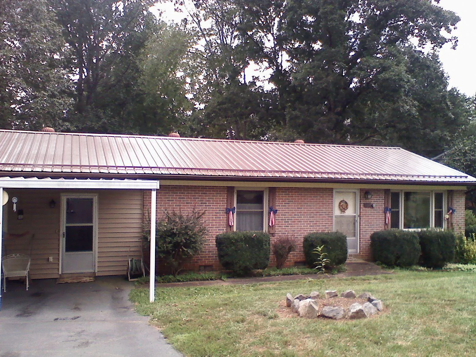 Bronze metal roof and carport on a brick ranch home — Roof Repair work by our crew in Kyburz